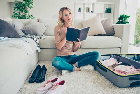 Woman planning out her cabin packing list.