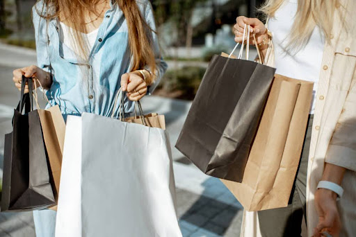 Two girls carrying shopping bags from various stores
