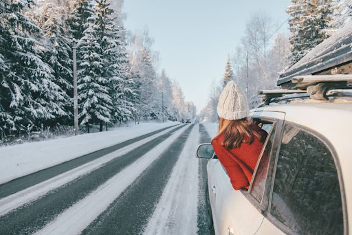 Girl looking out the car window driving down a snowy road during a Eureka Springs Arkansas winter getaway.


