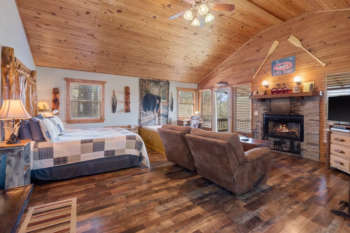 Cabin living room with a stone wood-burning fireplace and custom built-in furniture
